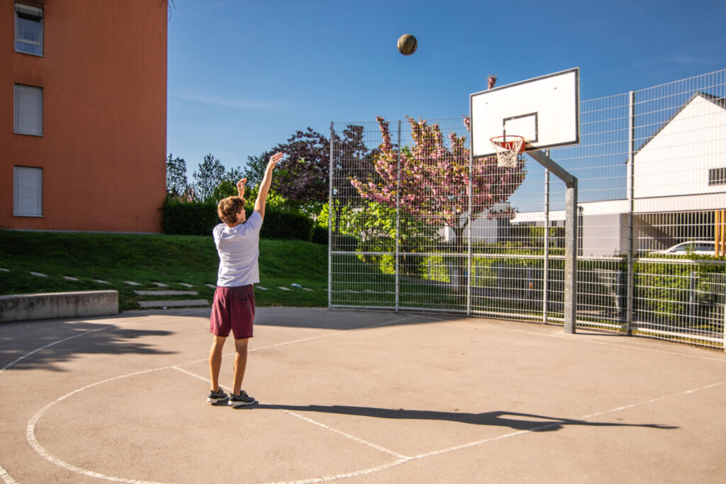 Basketball player demonstrating the catch and shoot technique, focusing on hand positioning, balance, and quick release for accurate shooting.